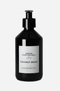 Sort flaske med pumpe, mærket "Urban Apothecary Coconut Grove", luksus hånd- og bodylotion.