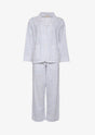 Hvid nattøjssæt med marineblå prikker, langærmet skjorte og bukser.