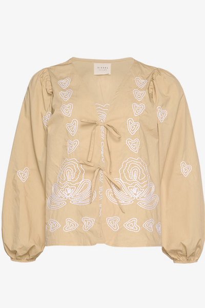 Beige bluse med hvidt broderi, puffede ærmer, V-hals og blomster- og hjertebroderi.