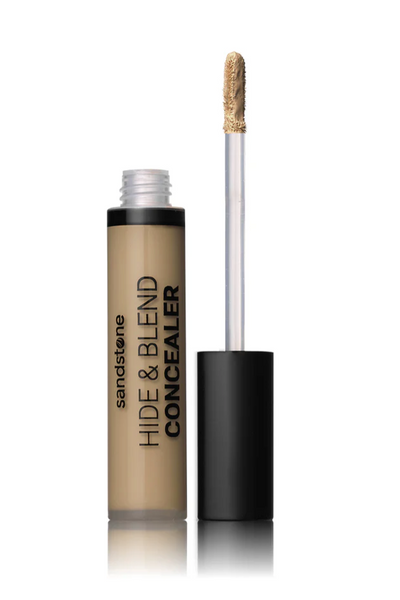 Flydende concealer i åben flaske med sort låg og applikator. Tekst: "HIDE &amp; BLEND CONCEALER."